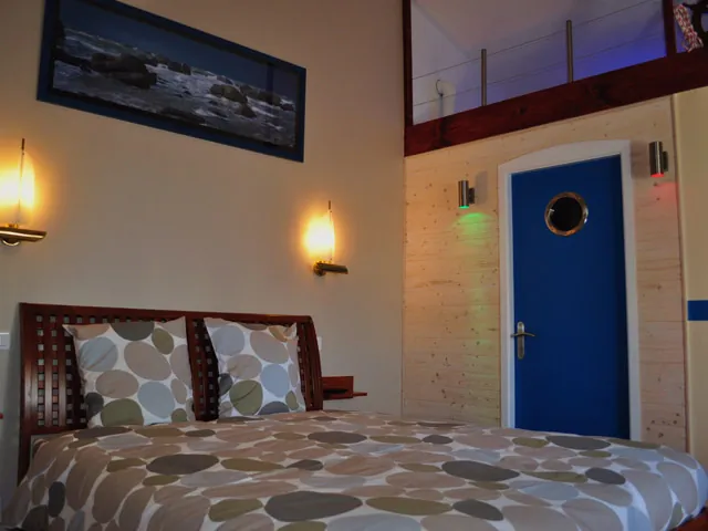 La chambre familiale Vague : le grand lit et la porte au hublot